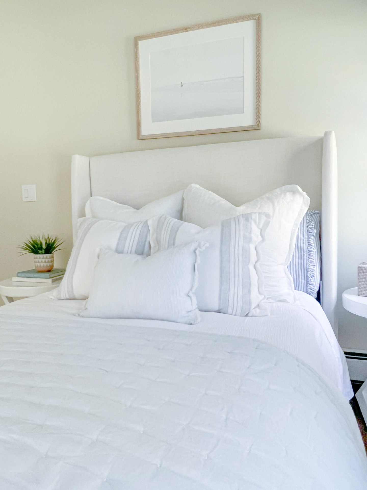 bedroom with white bed, pillows and surfer artwork