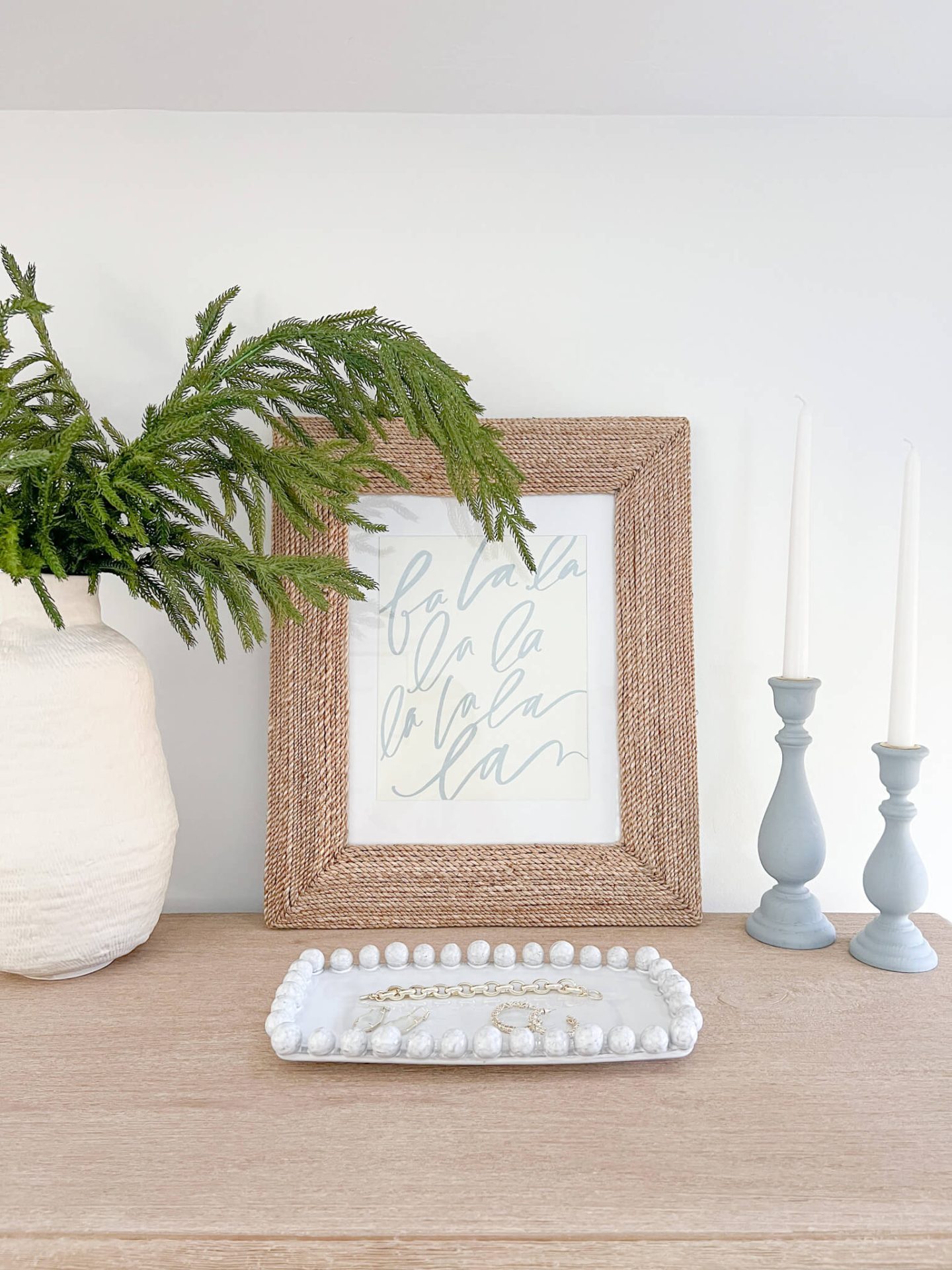 fa la la la print in wood frame with white tray in front of it