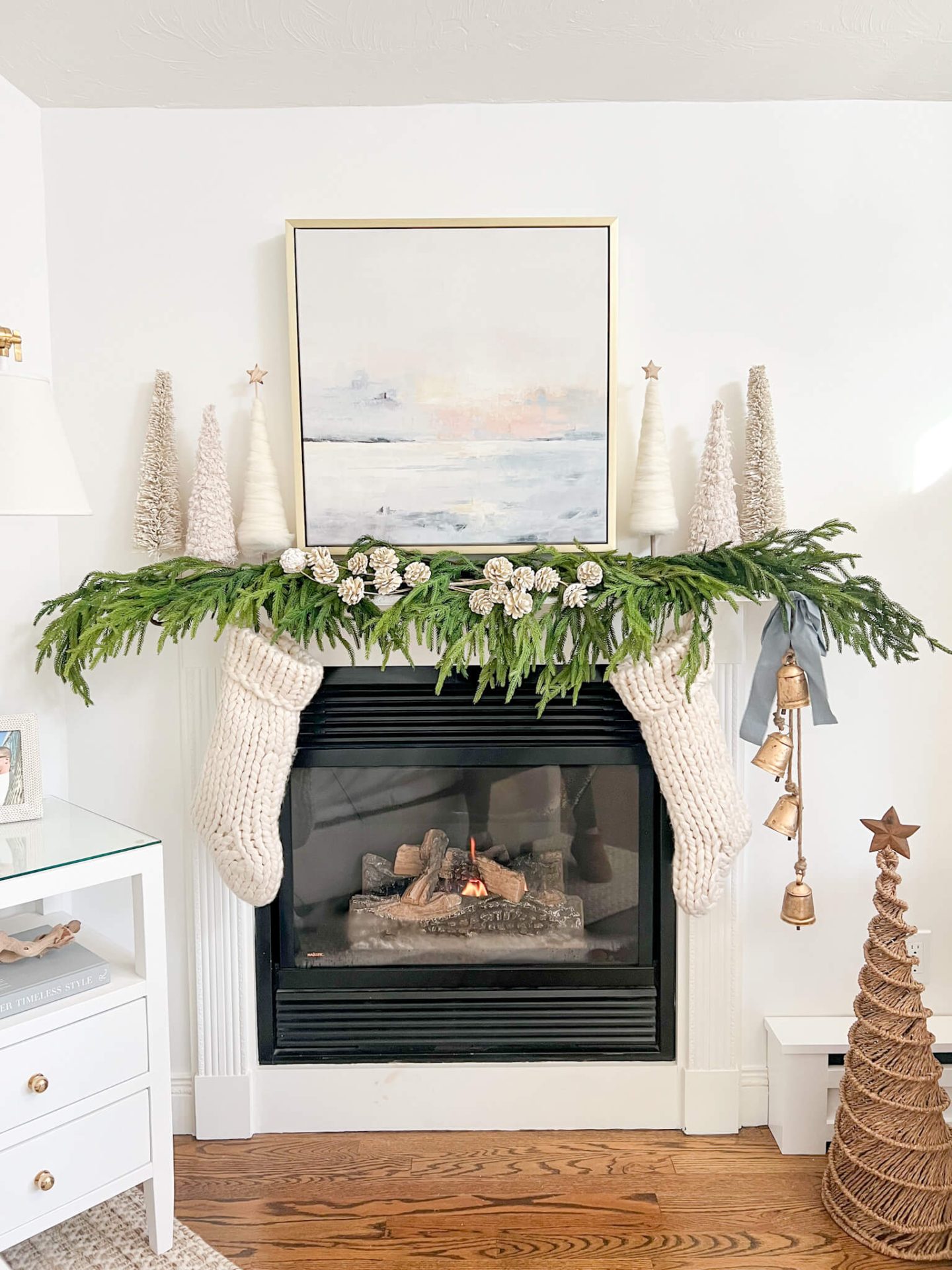 coastal christmas decorated mantel with white stockings and white christmas trees