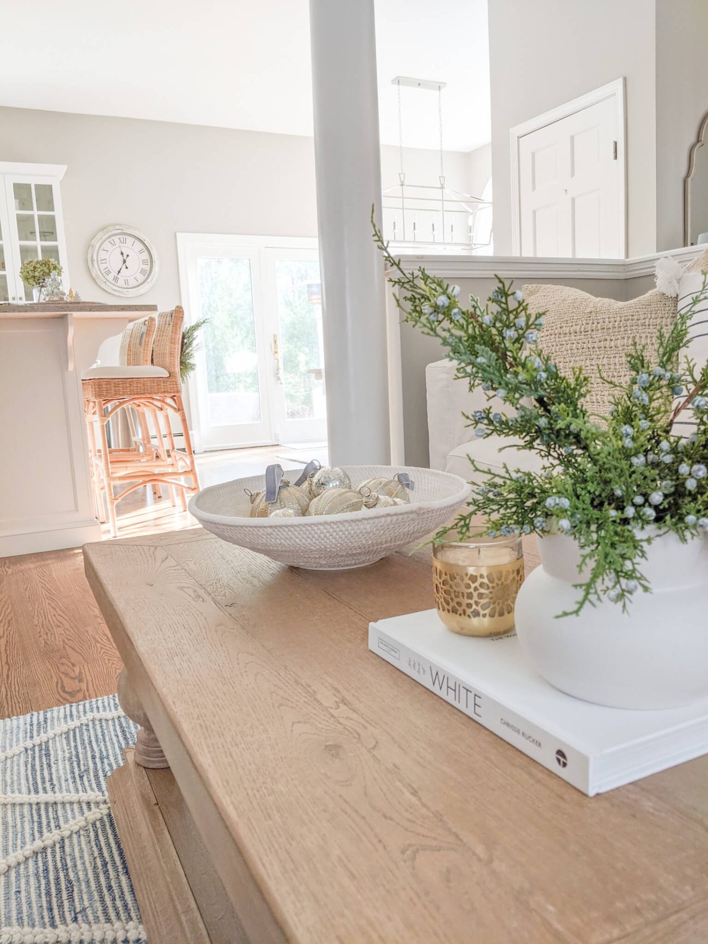 silver ornaments in a bowl on a coffee table with woven kitchen stools in the background