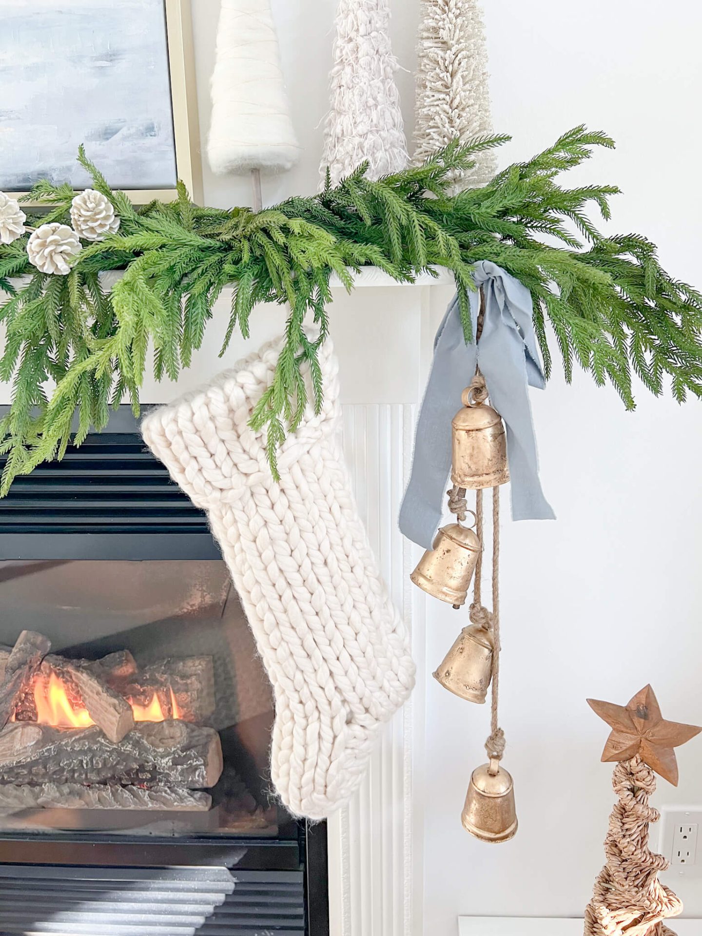 closeup of bells and light blue ribbon hanging from mantel