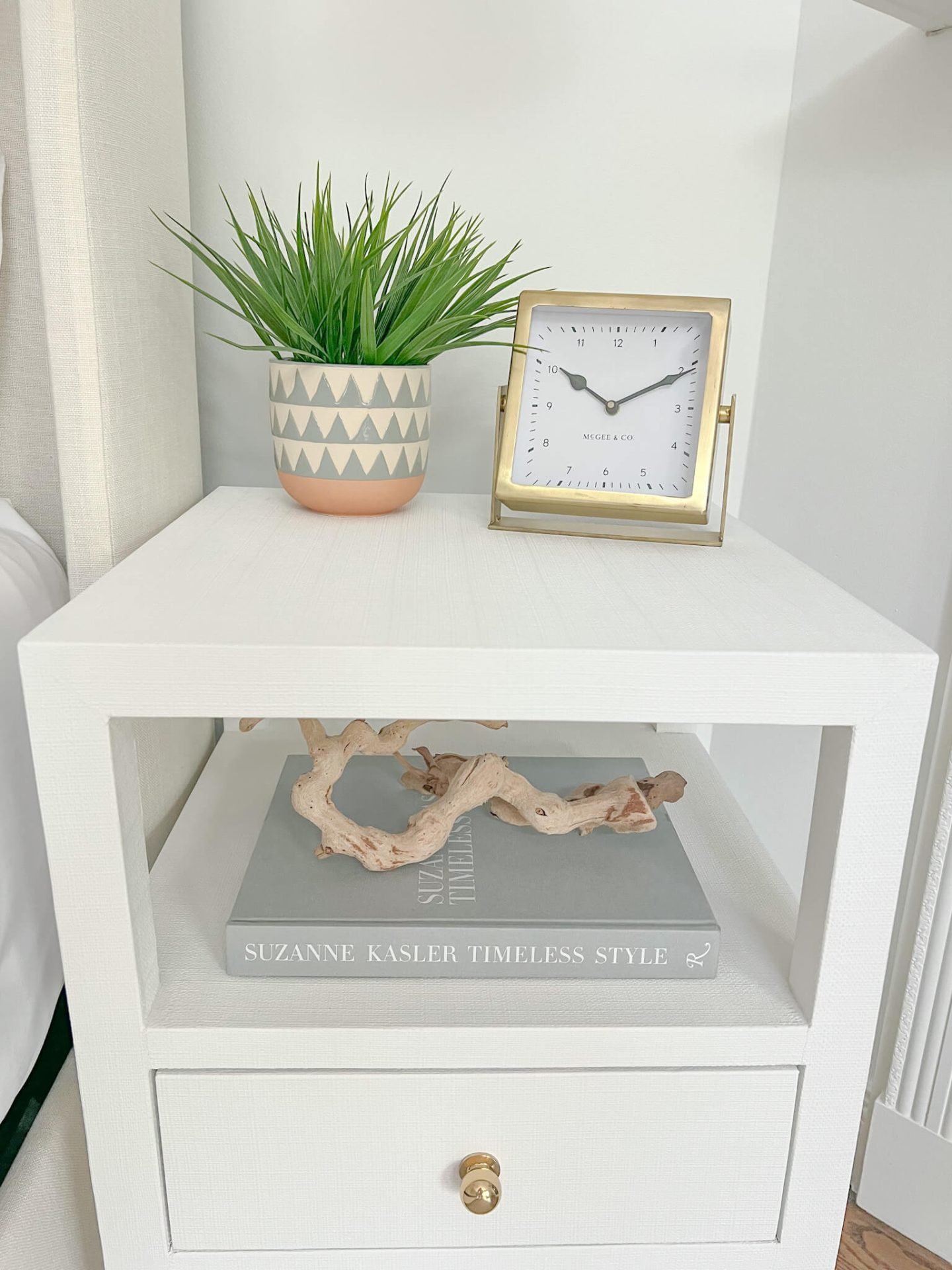 white coastal nightstand with small plant and clock