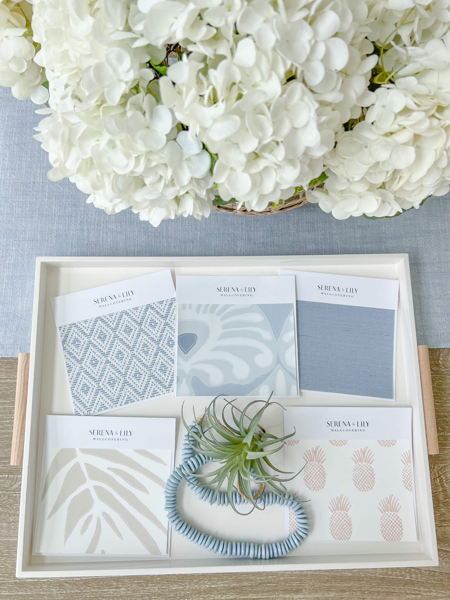 flatlay of 5 serena and lily, coastal aesthetic wallpaper samples and hydrangeas