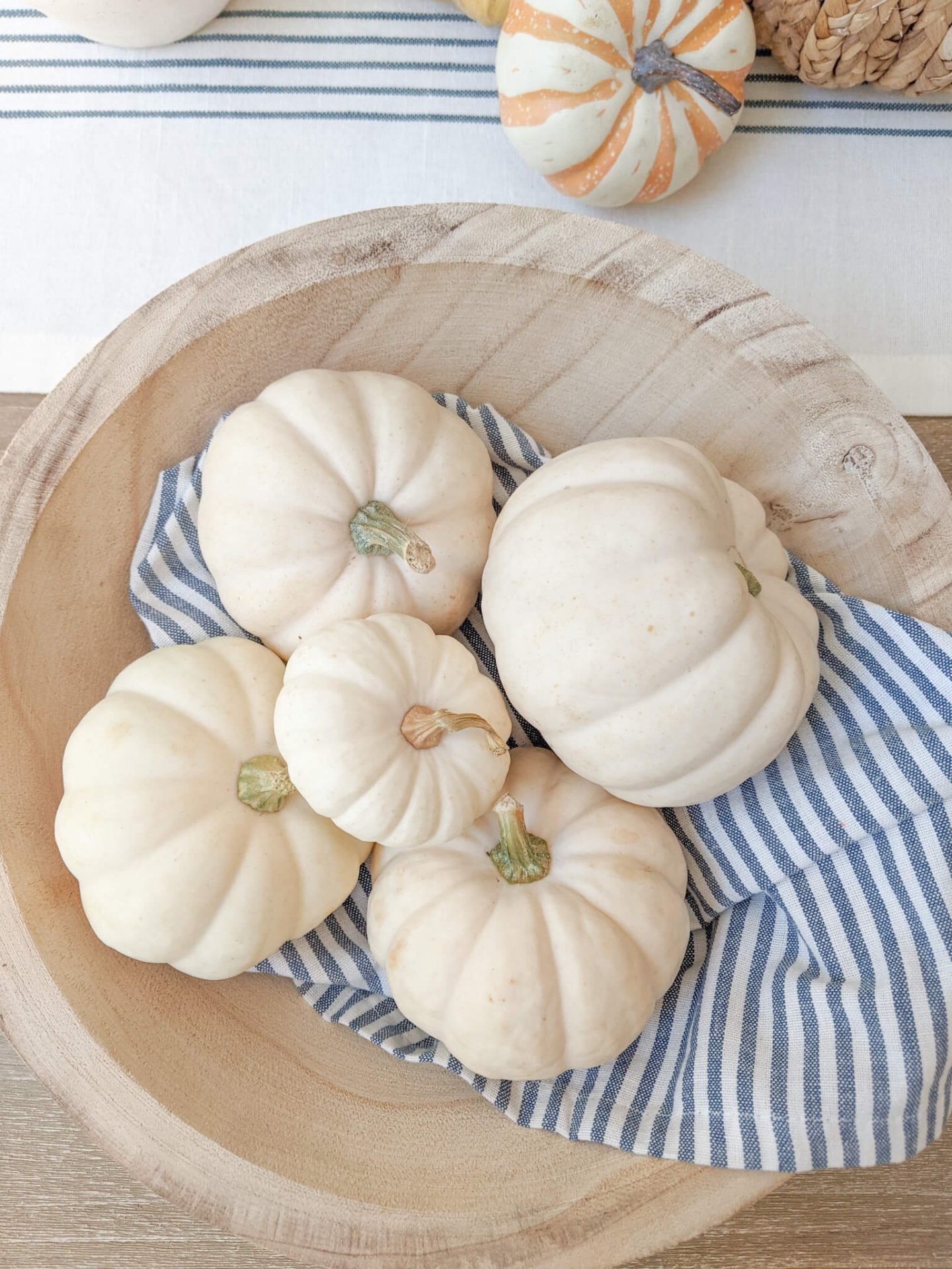 bowl of white pumpkins on a white and blue napkin