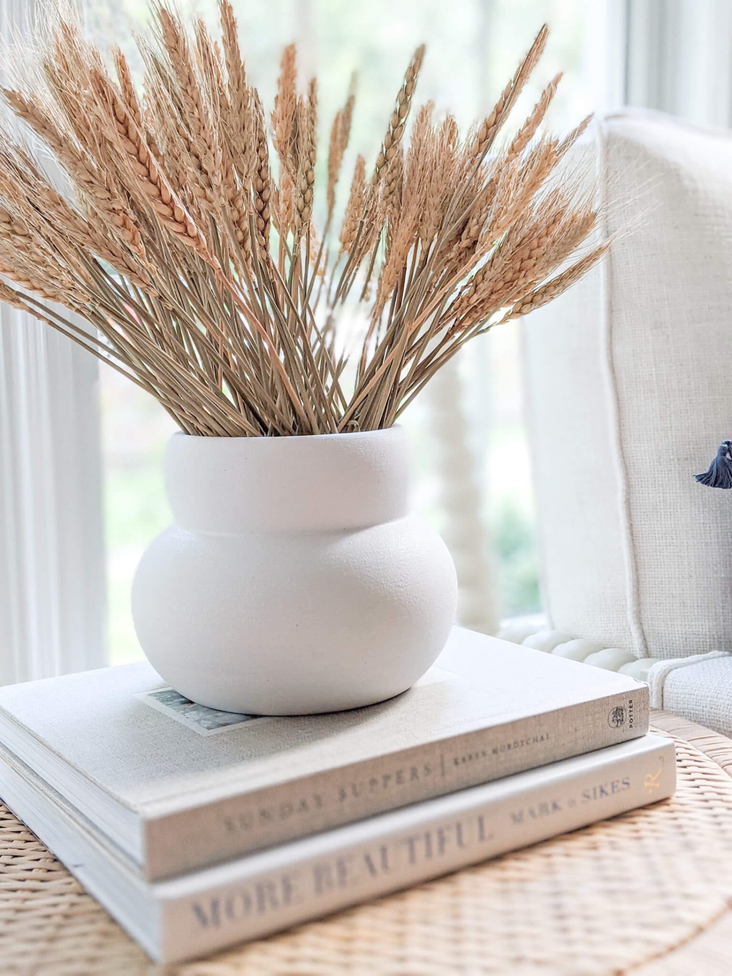 closeup of a white vase with dried wheatgrass in it