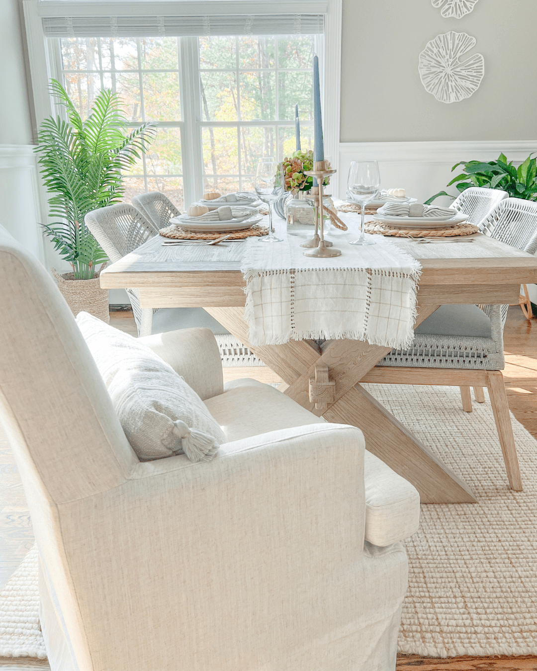 wood table with white table runner and fabric chair at the head of the table