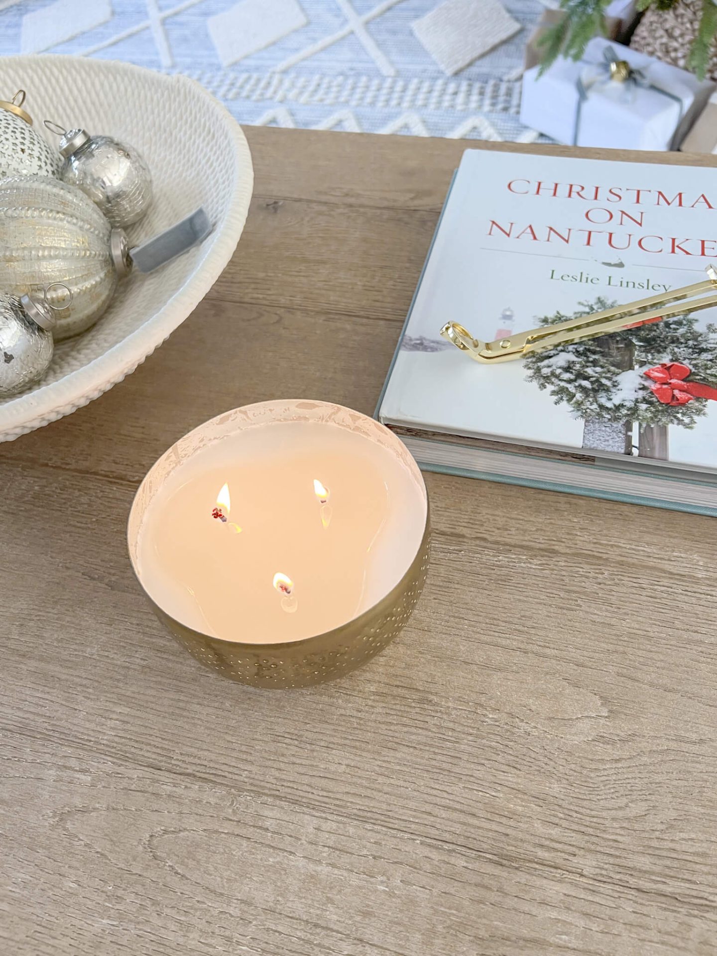 candle on coffee table next to bowl with ornaments