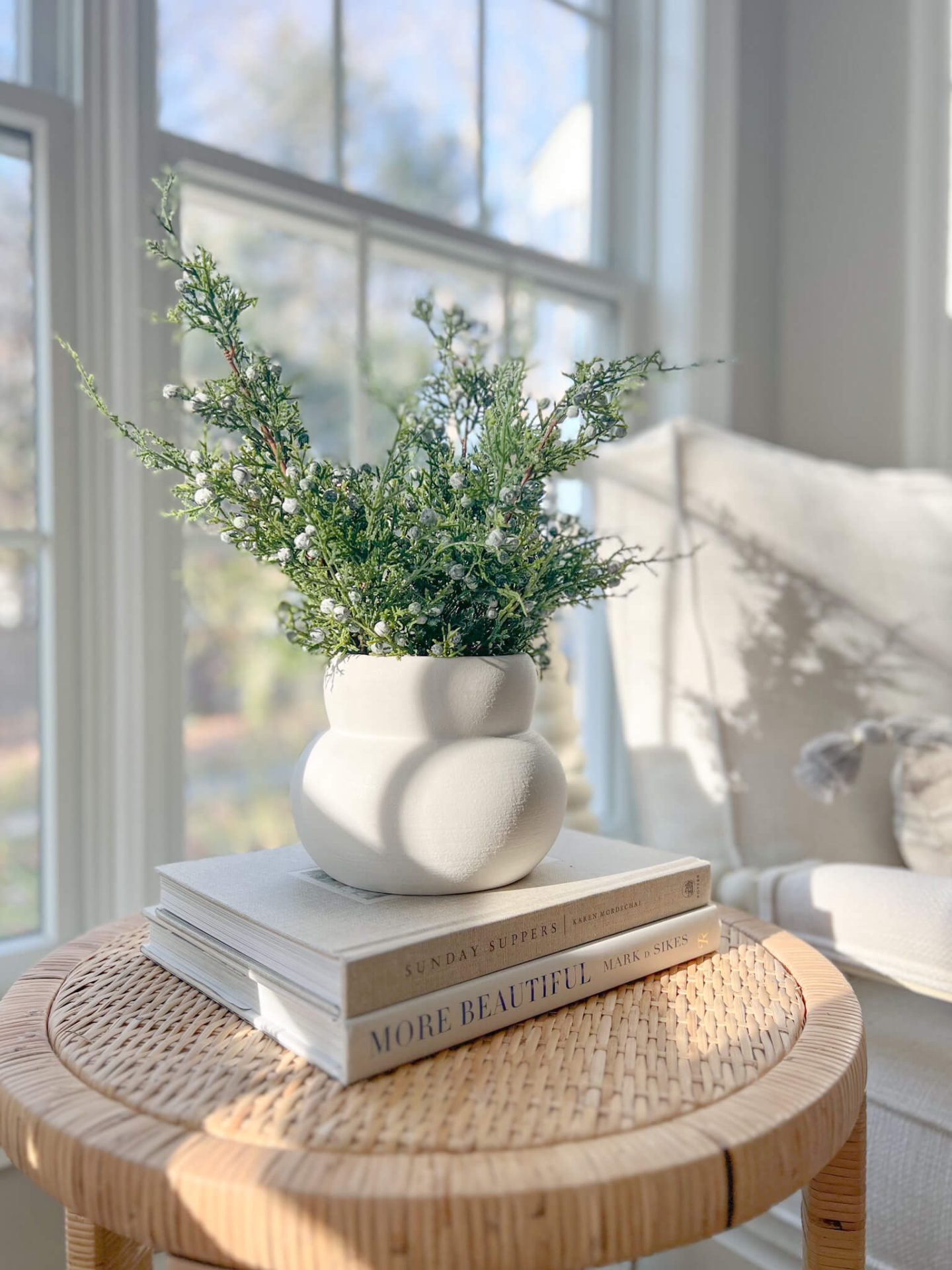 Christmas stems in a white vase on a side table