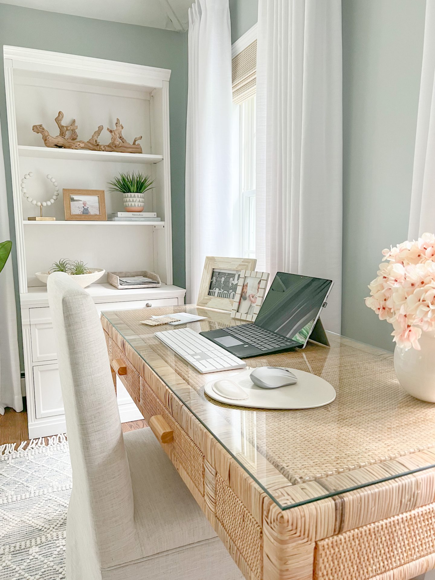 coastal home office with white bookshelf & rattan desk